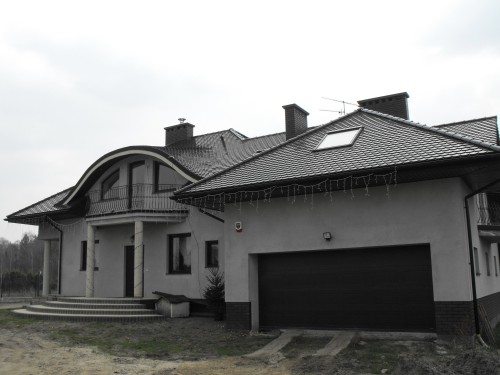 Dom jednorodzinny, stolarka PVC CT70 CAVA, kolor Dąb brązowy, drzwi stalowe, brama segmentowa Krispol
