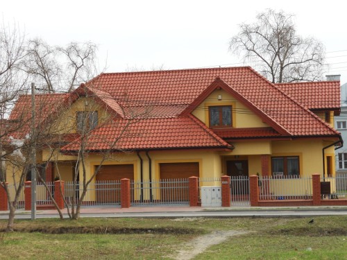 Dom jednorodzinny, stolarka PVC CT70 CAVA, kolor Złoty dąb, drzwi wejściowe PVC SCHÜCO, bramy garażowe KRISPOL
