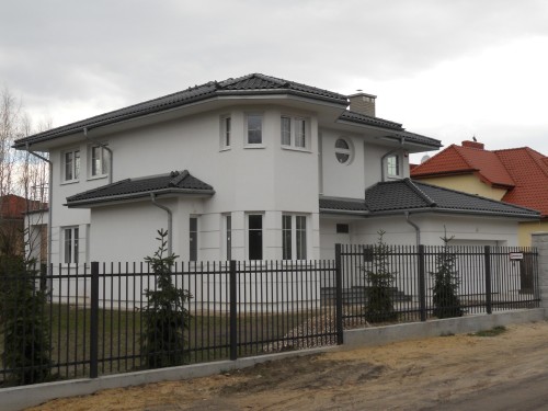 Duży dom jednorodzinny, stolarka PVC CT70 CAVA, kolor biały, szprosy międzyszybowe, brama garażowa Krispol z przetłoczeniami szerokimi