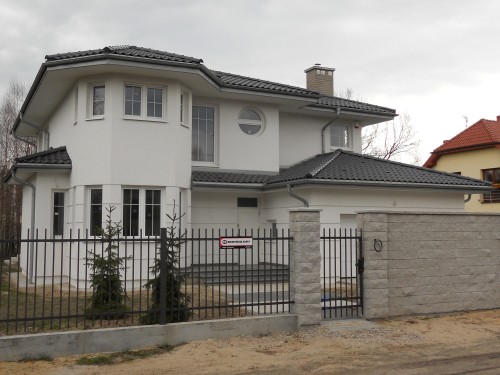 Duży dom jednorodzinny, stolarka PVC CT70 CAVA, kolor biały, szprosy międzyszybowe, brama garażowa Krispol z przetłoczeniami szerokimi